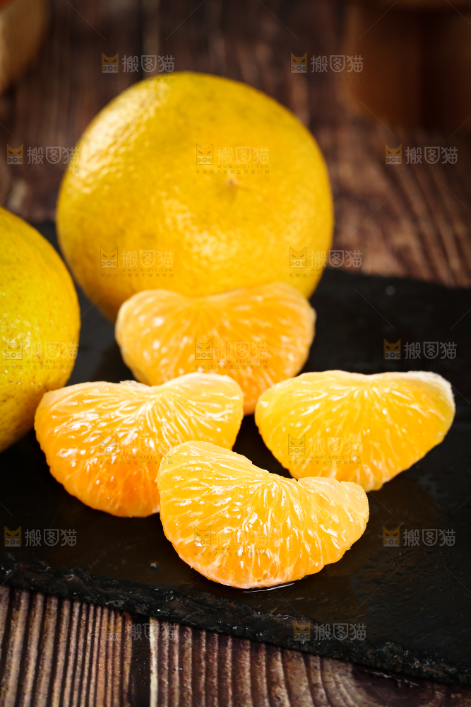 黑底上摆放着桔柚和桔柚果肉