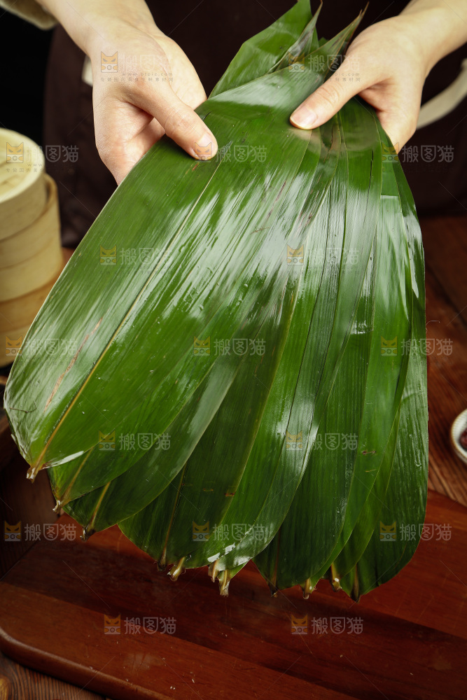 手里拿着天然粽子叶