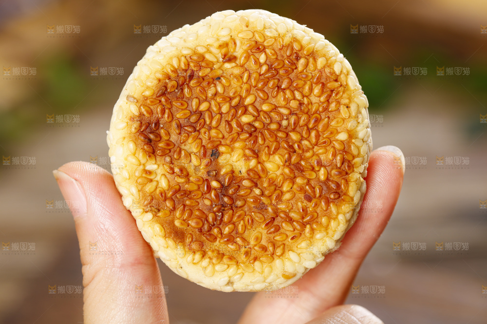 手里拿着手工芝麻饼