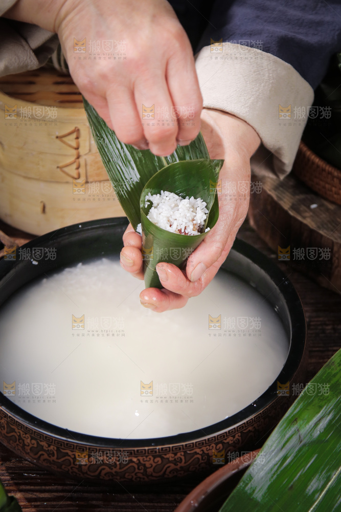手里包着糯米粽