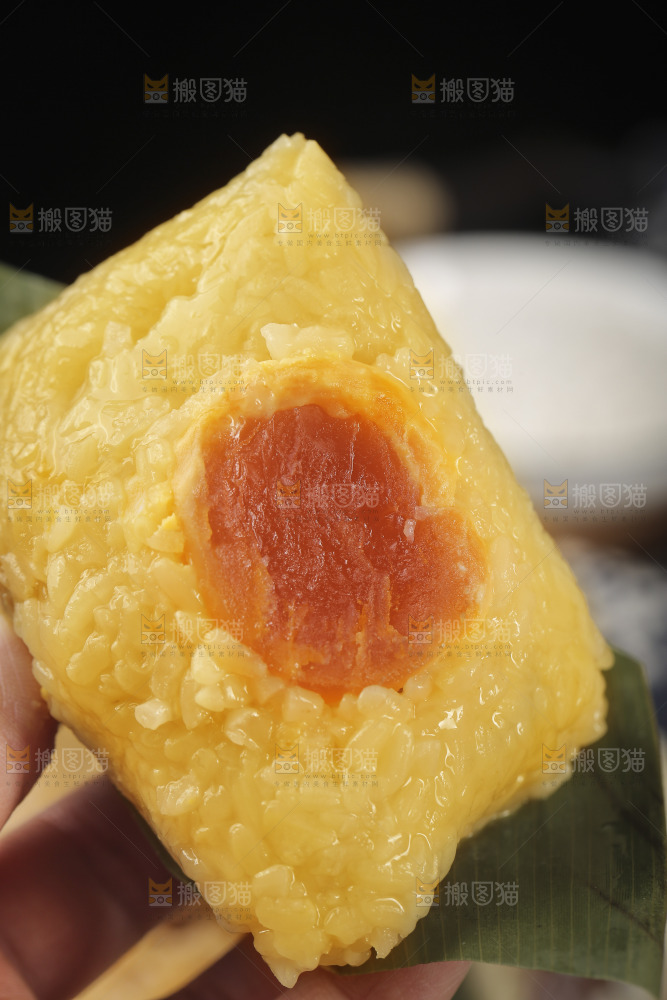 手里拿着蛋黄粽