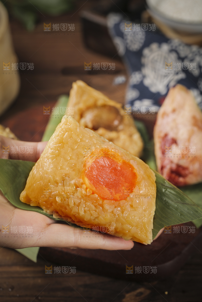 手里拿着蛋黄粽