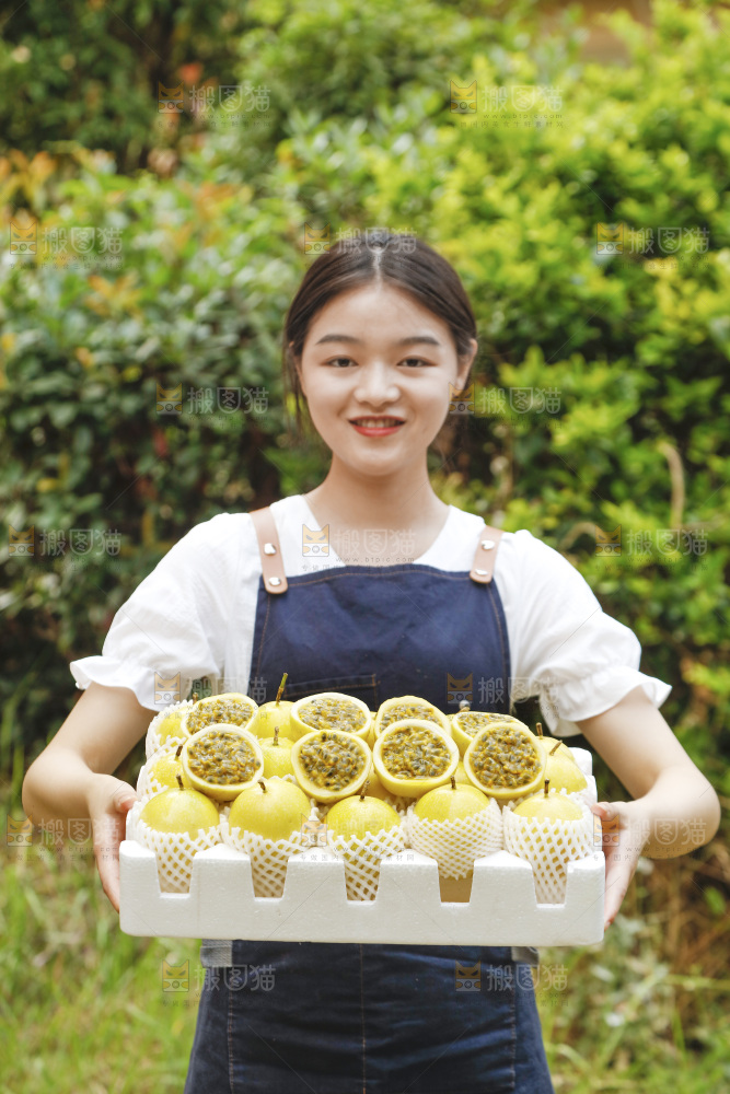 女孩手上端着一箱黄金百香果