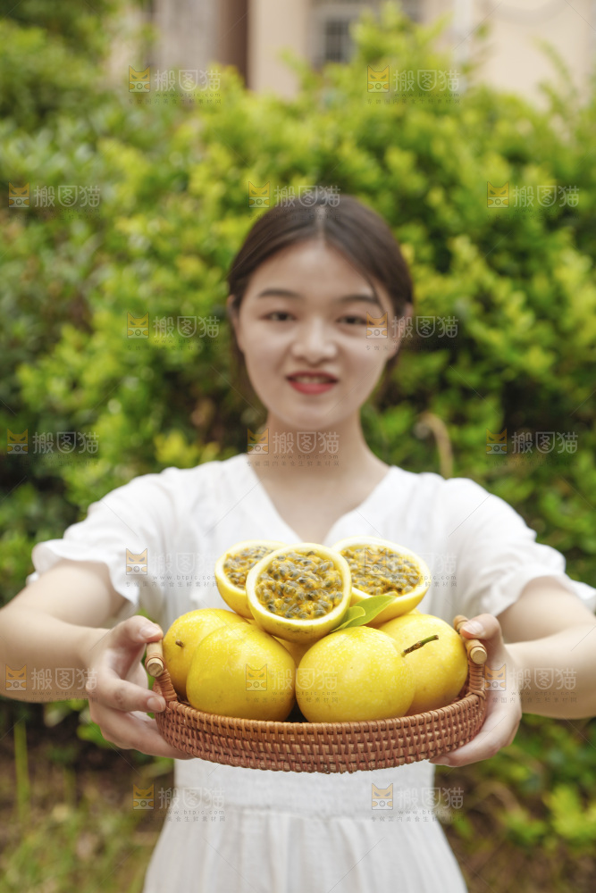 女孩手里端着一篮黄金百香果