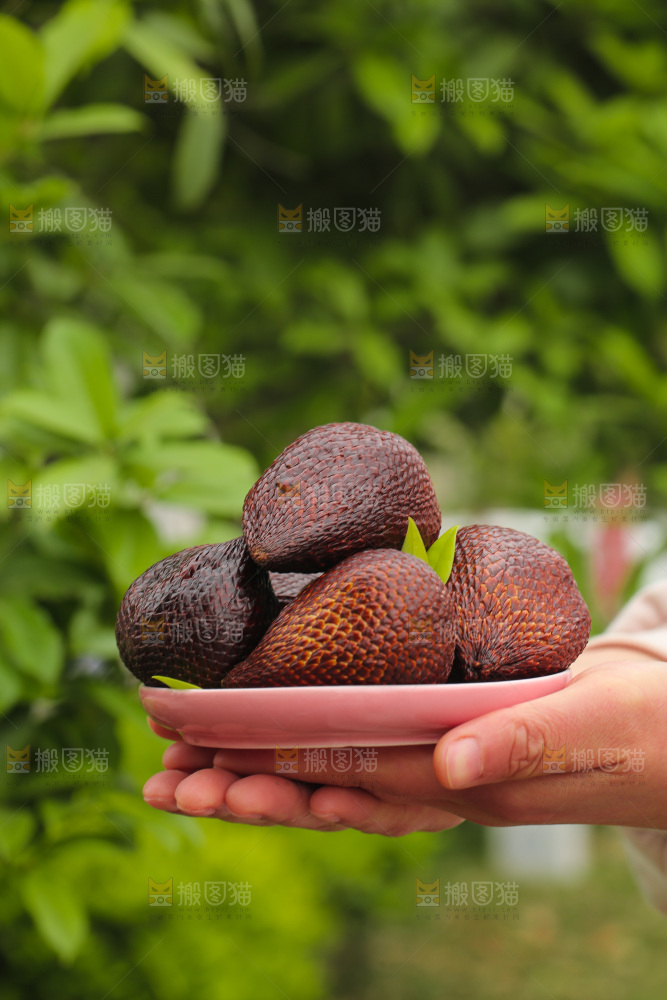 手里端着一盘蛇皮果