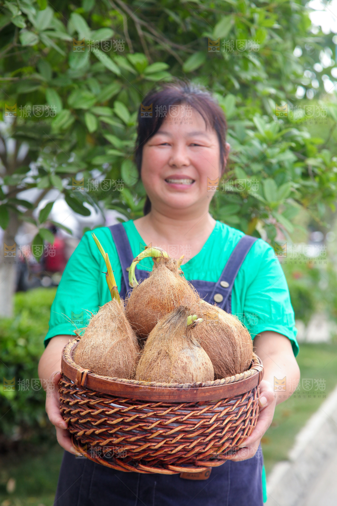 女人手里端着一篮新鲜椰宝
