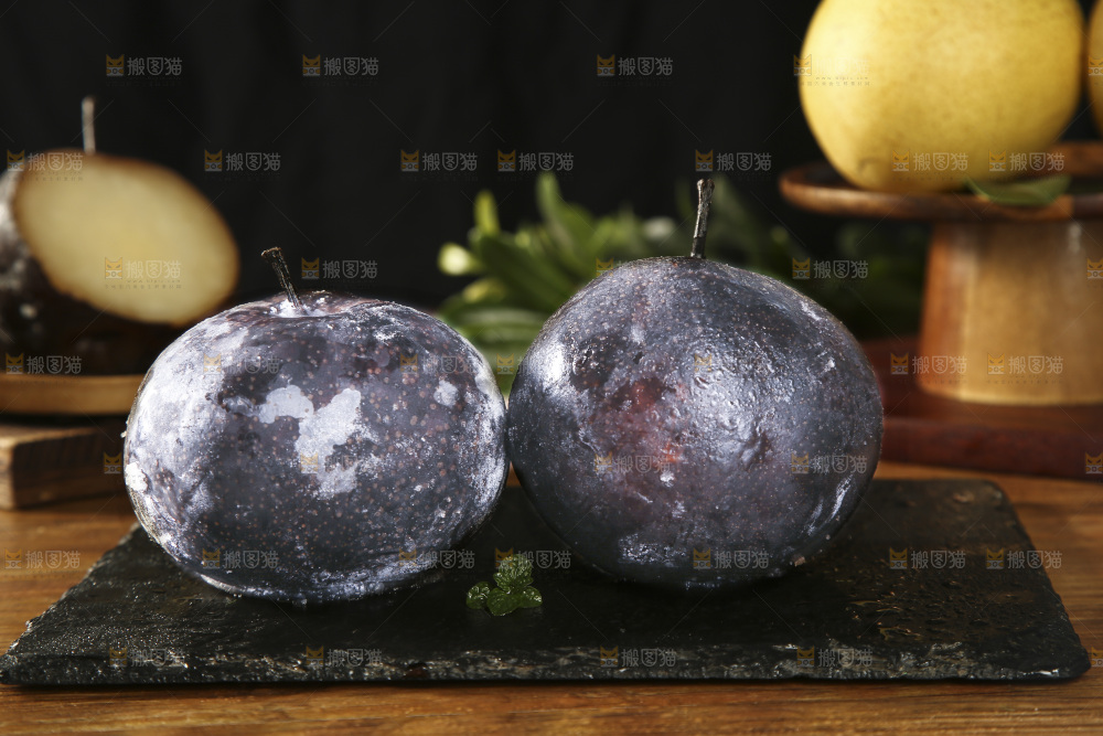 黑石板上放着两个黑冻梨