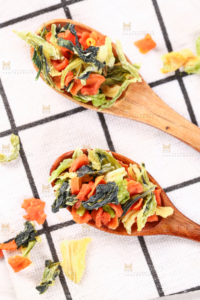 格子布上勺子里的混合蔬菜干