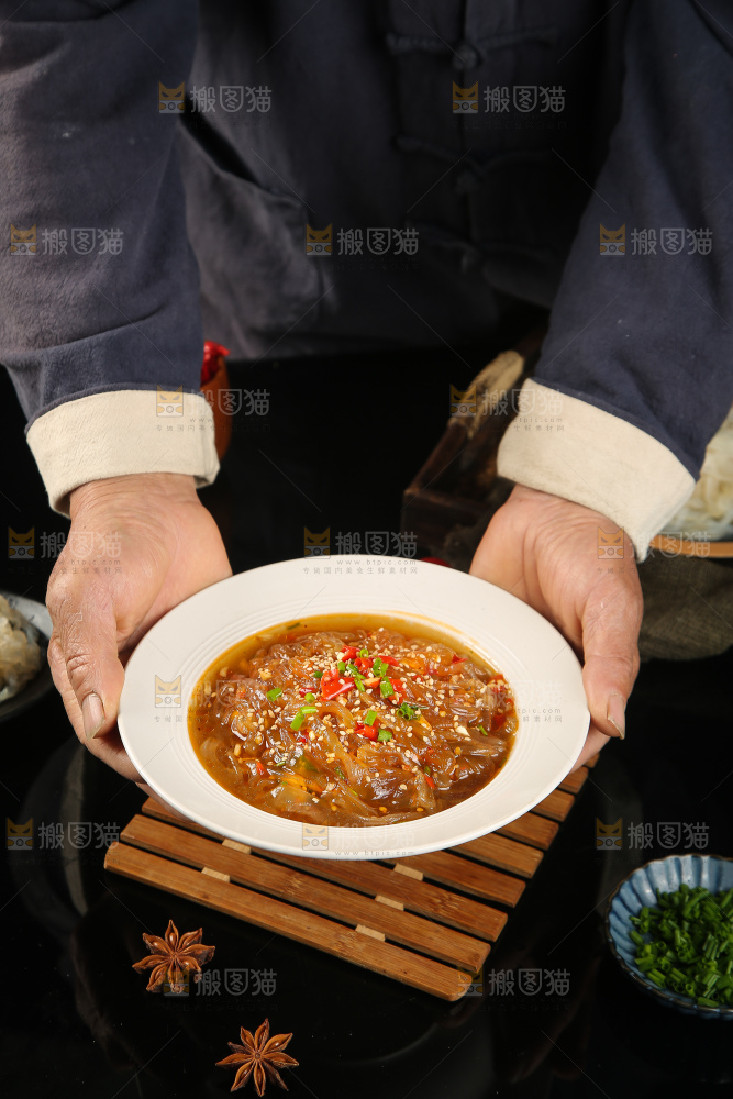 手里端着一盘酸辣海蜇丝