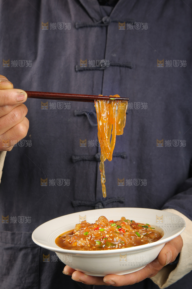 手里端着一盘凉拌海蜇