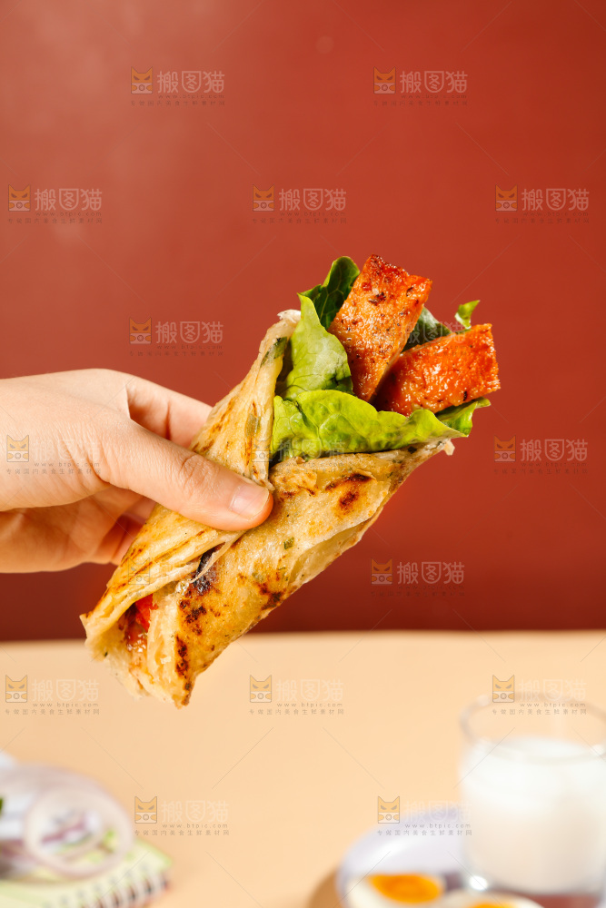 手上拿着一个卷饼
