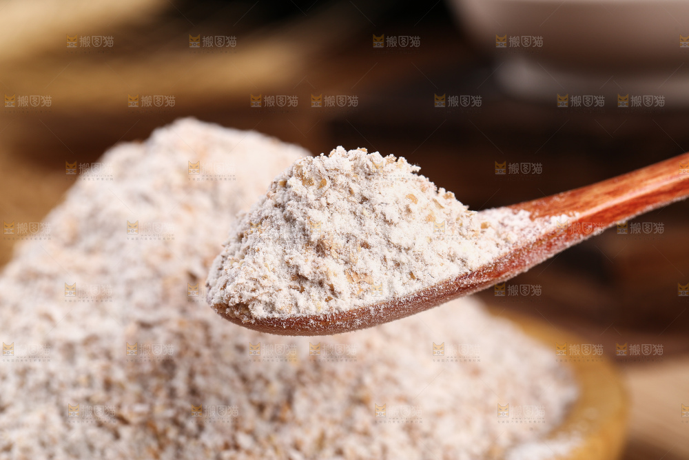 勺子上舀着黑全麦粉