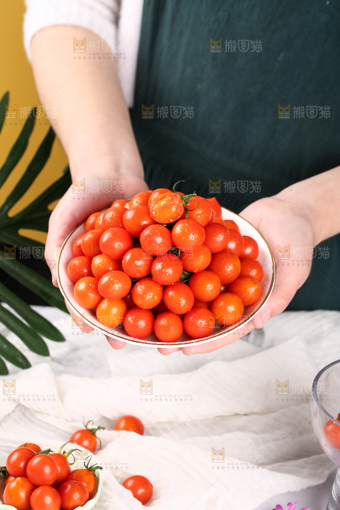手里端着一盘珠珠小番茄