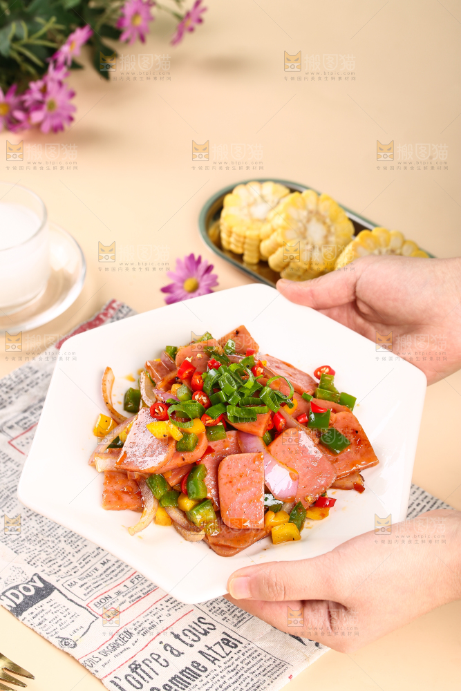 手里端着一盘辣椒炒火腿肉