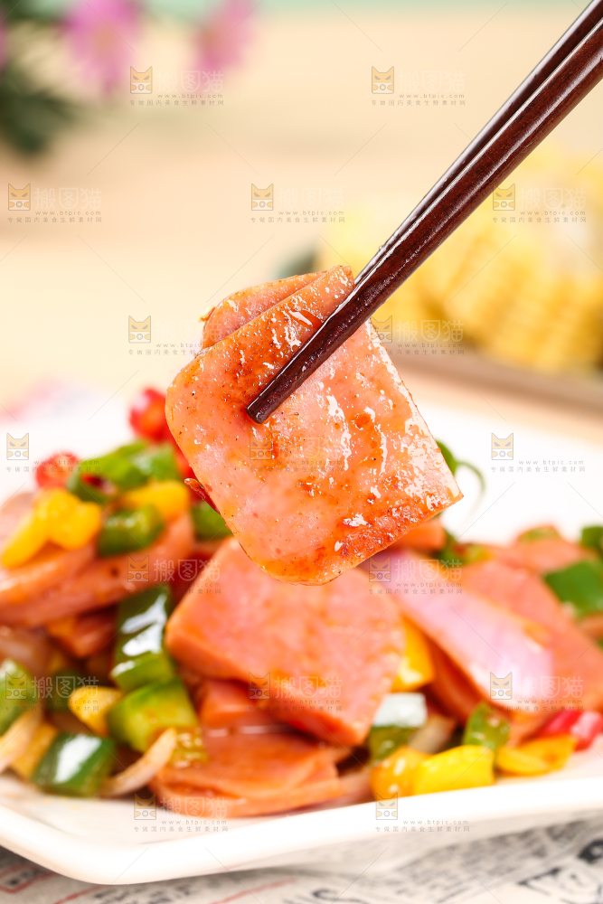 筷子上夹着午餐肉