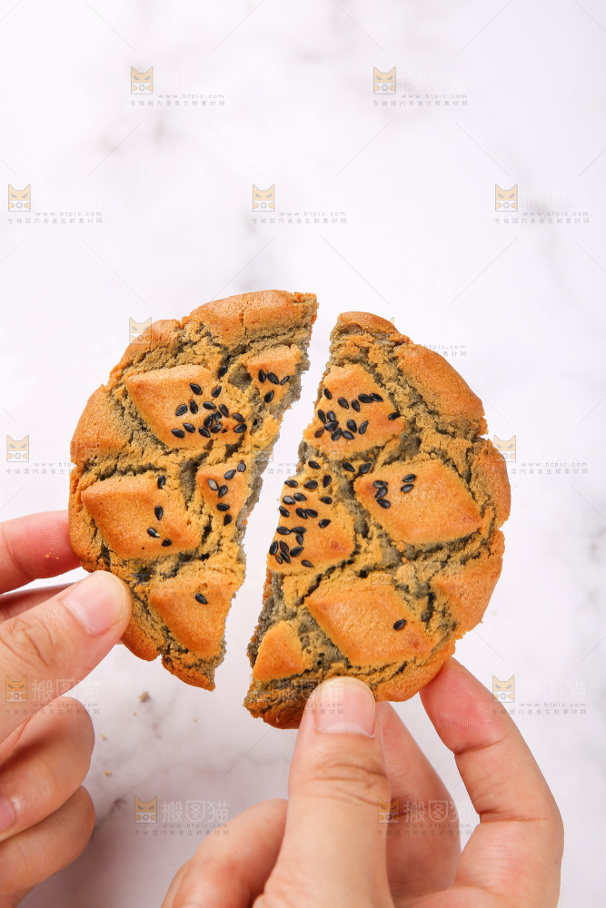 手拿着芝麻夹心桃酥饼