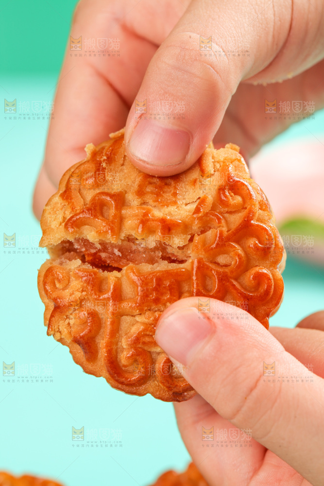 手拿着掰开的蛋黄月饼
