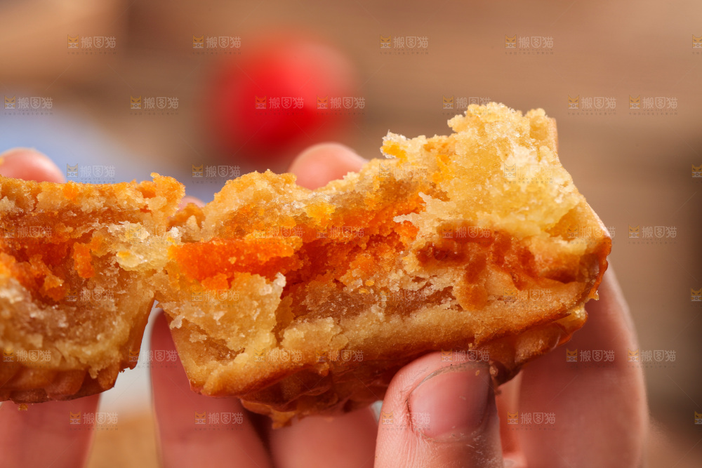手拿着掰开的蛋黄月饼