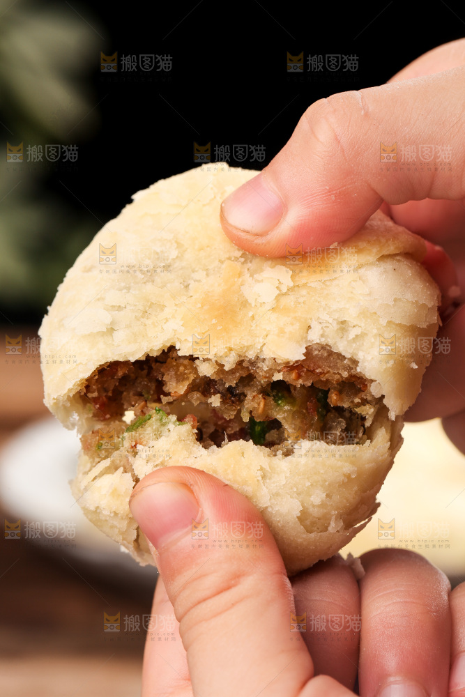 手拿着掰开的酥皮月饼