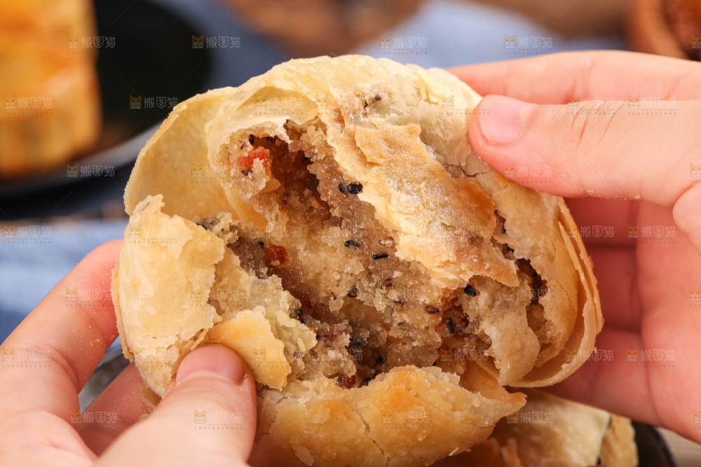 手拿着掰开的酥皮月饼