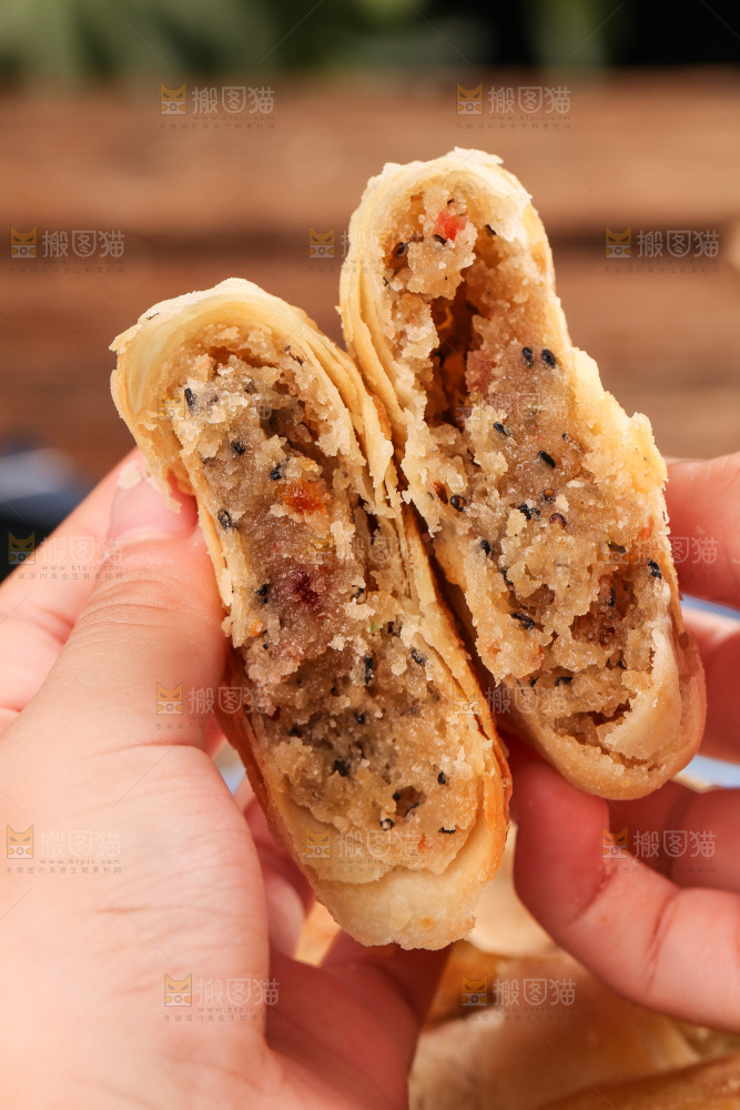 手拿着掰开的酥皮月饼