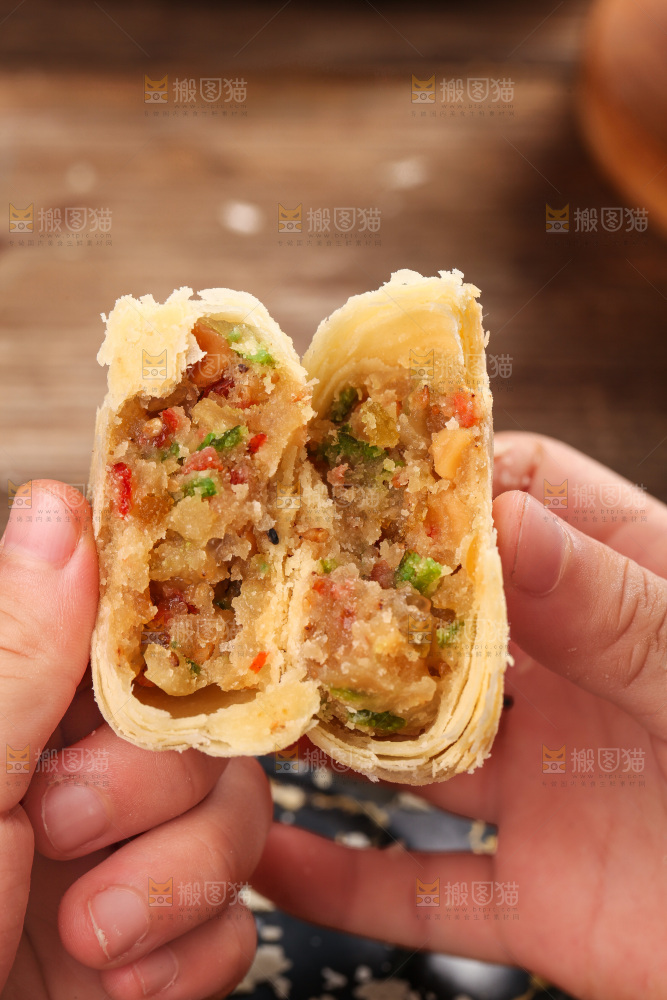 手拿着掰开的酥皮月饼