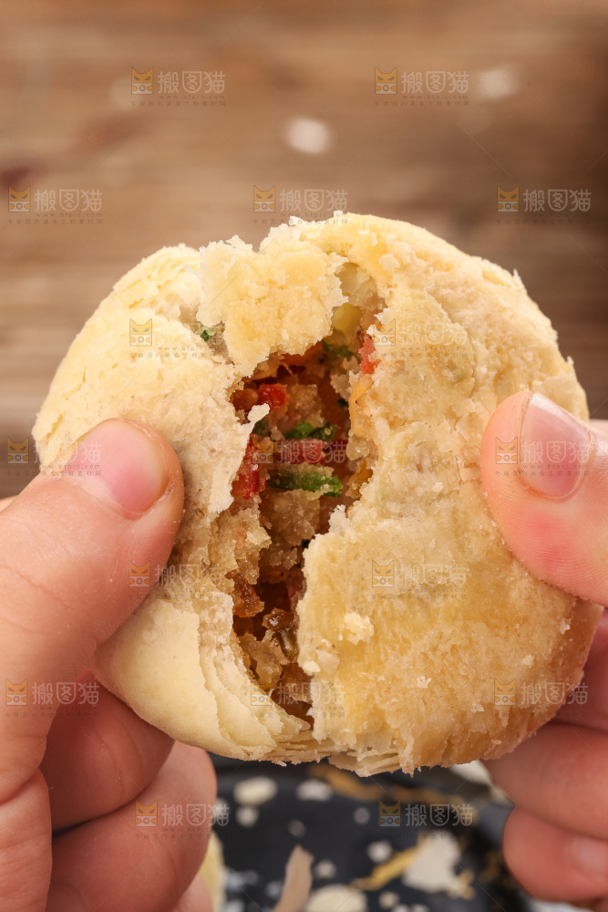 手拿着掰开的酥皮月饼