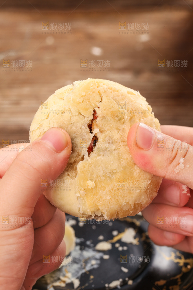 手拿着掰开的酥皮月饼