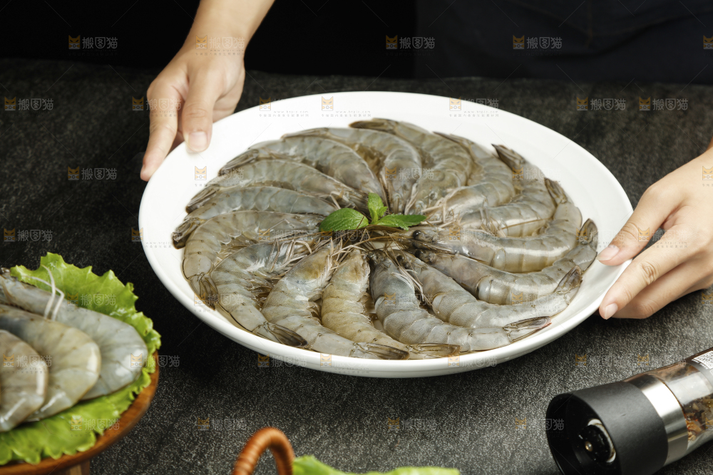 手上端着一盘对虾