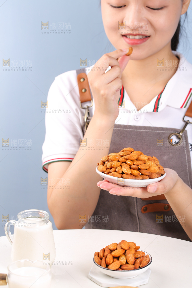 女孩手上拿着一盘巴旦木