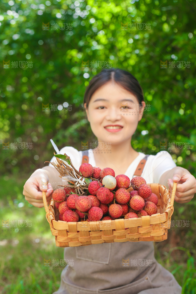 女人手上拿着一筐无核荔枝