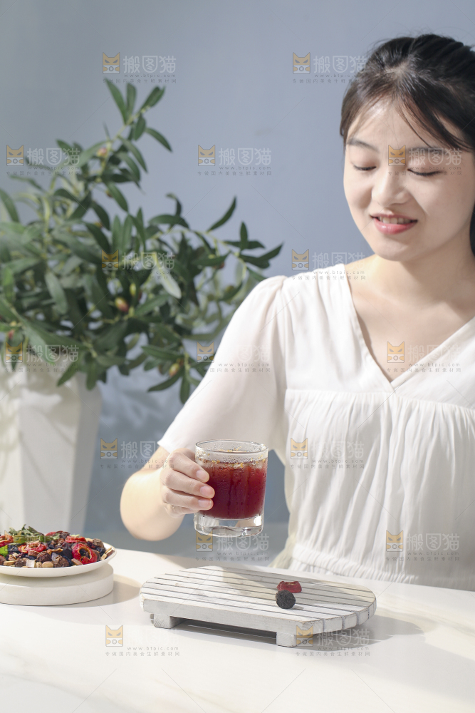 女孩手上拿着一杯酸梅汤