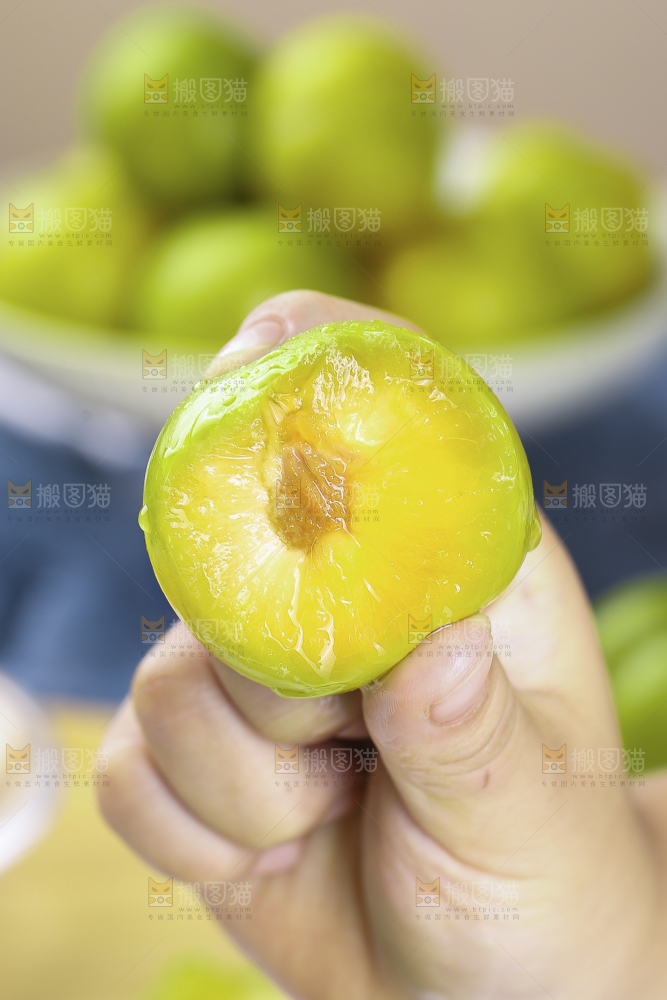 手上拿着蜂糖李