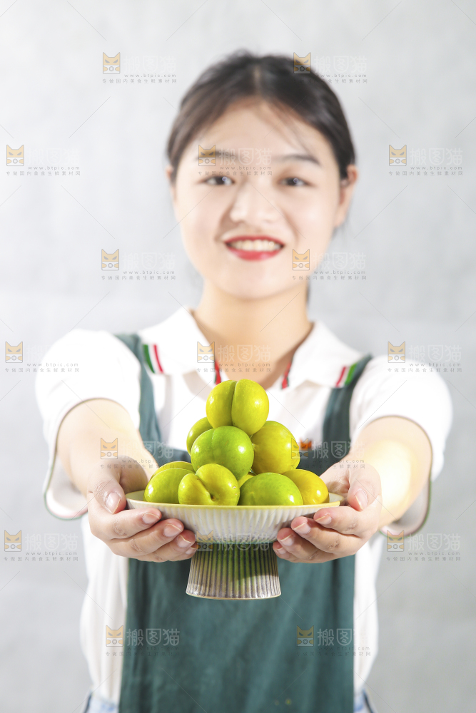 女孩手上捧着一盘蜂糖李