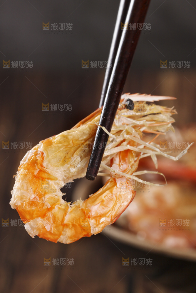 筷子上夹着碳烤虾