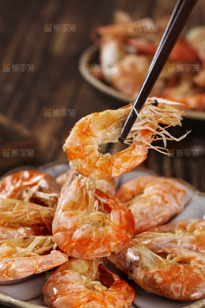 筷子上夹着碳烤虾