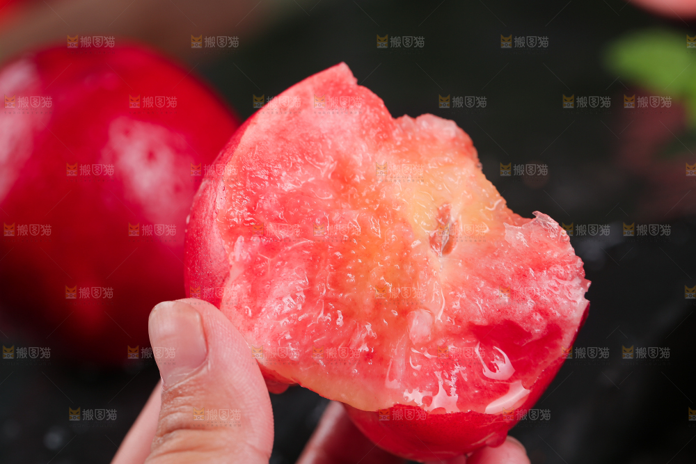 手上拿着红肉油桃