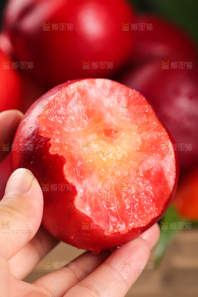 手上拿着红肉油桃