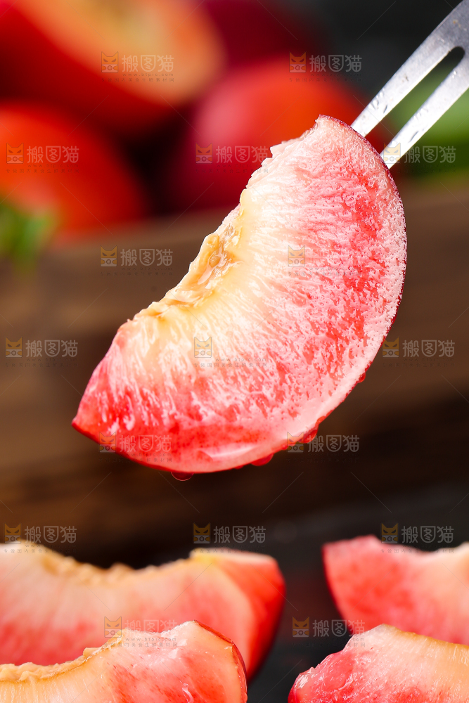 叉子上叉着的红肉油桃