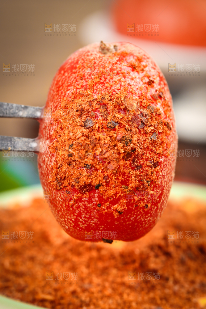 叉子插着蘸辣椒粉的羊奶果