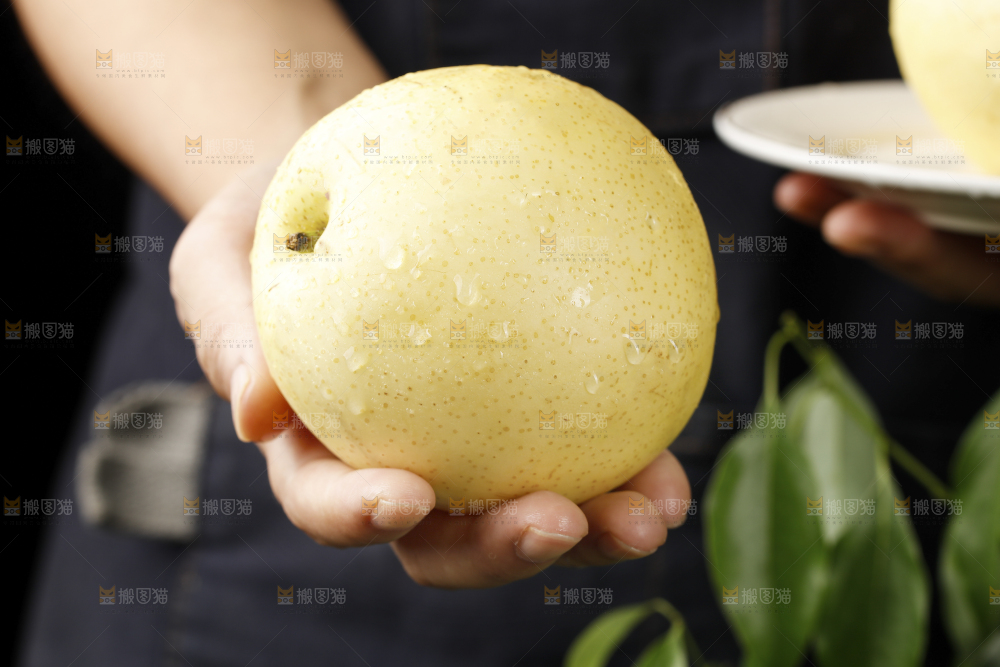 手上拿着新鲜皇冠梨
