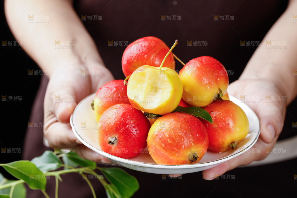 手上拿着一盘新鲜海棠果