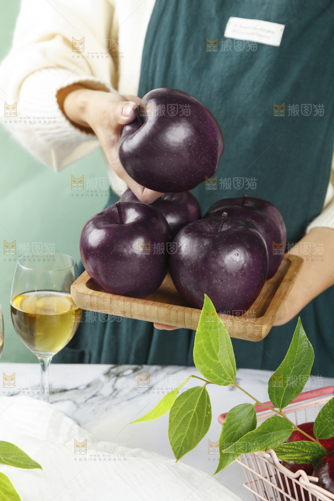 手上端着一盘黑苹果