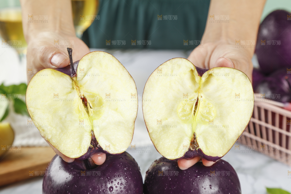 手上拿着掰开的黑苹果