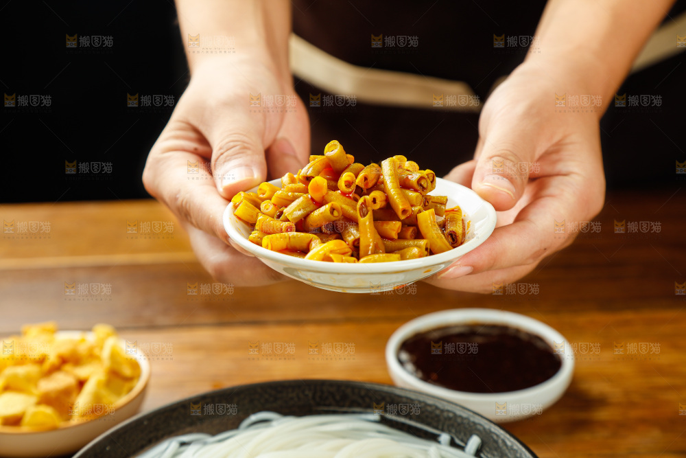 手端着一碟酸豆角
