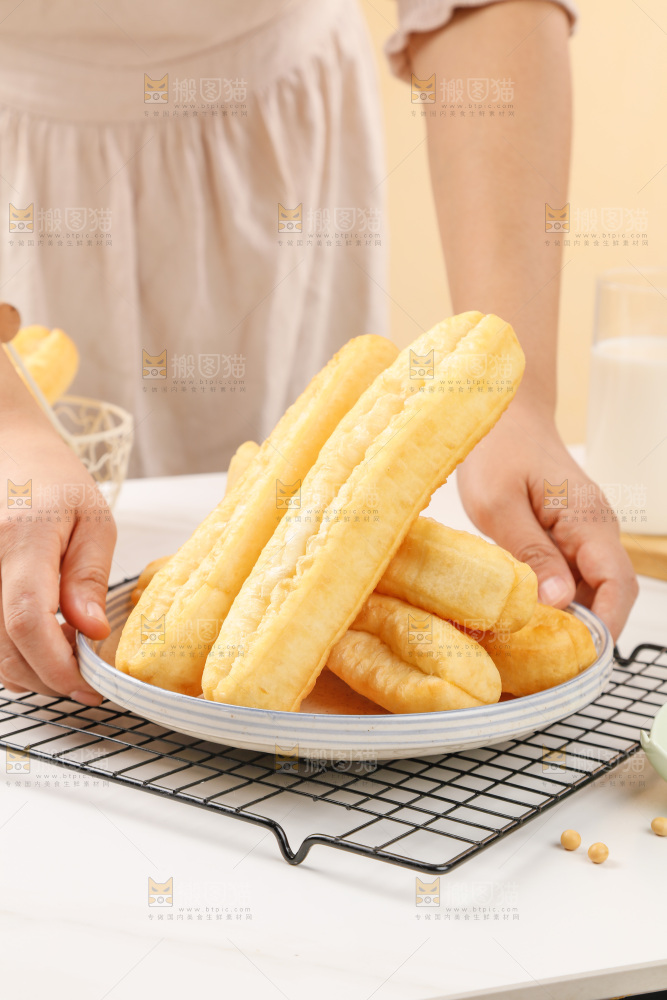 手里端着一盘油条