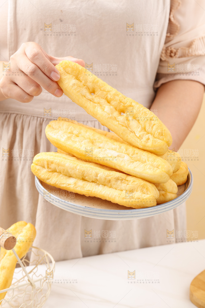 手里端着一盘油条