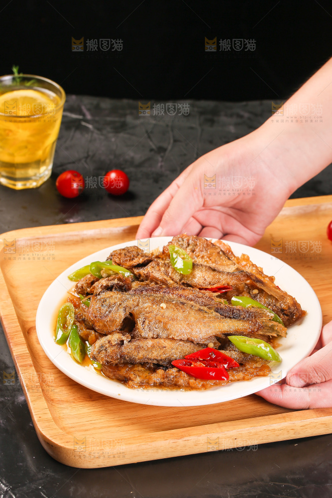 手端着一盘香酥煎鱼