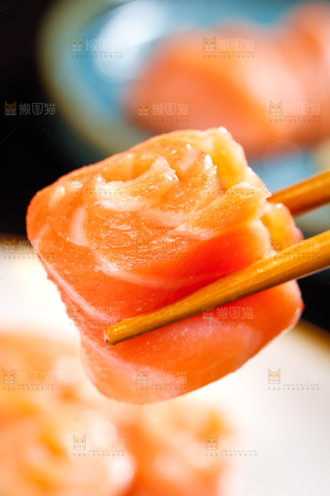 筷子上夹着三文鱼卷