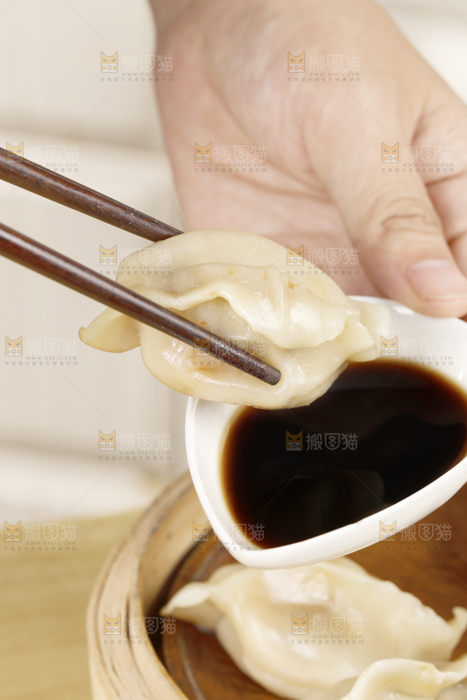 蘸着酱汁的手工饺子